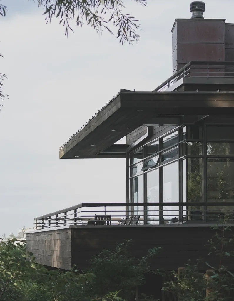 A cantilevered steel and glass structure projecting from a building.
