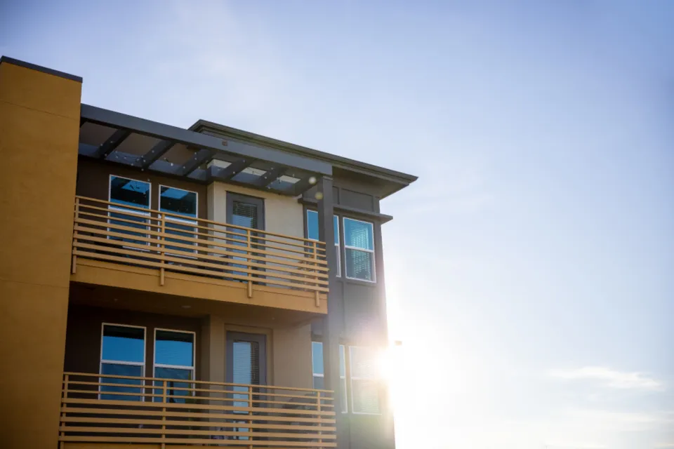 A timber and glass lodge-style building lit from inside at dusk.